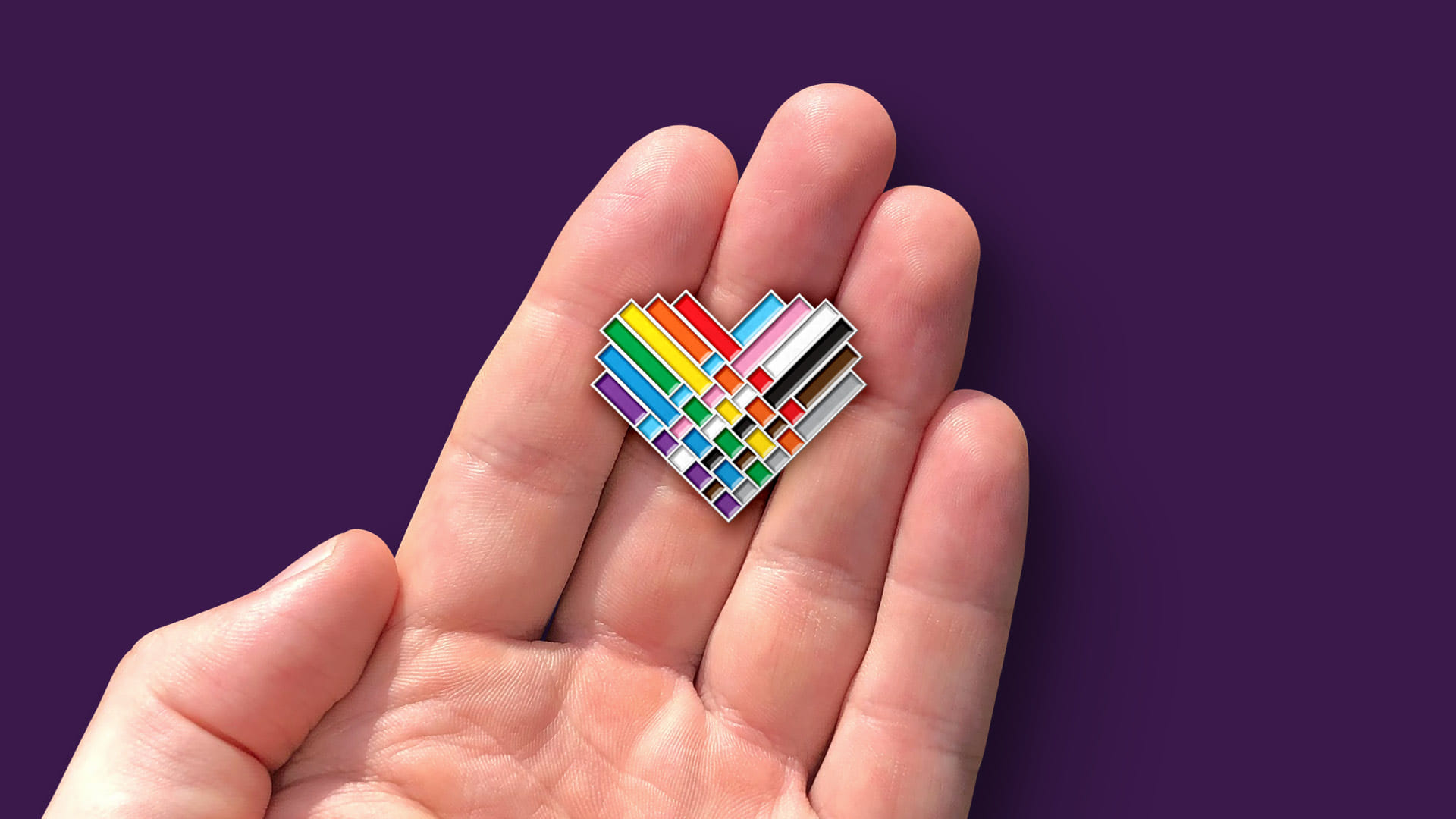The final logo design for the 2020 Wellington Pride Festival as a pin button badge mockup